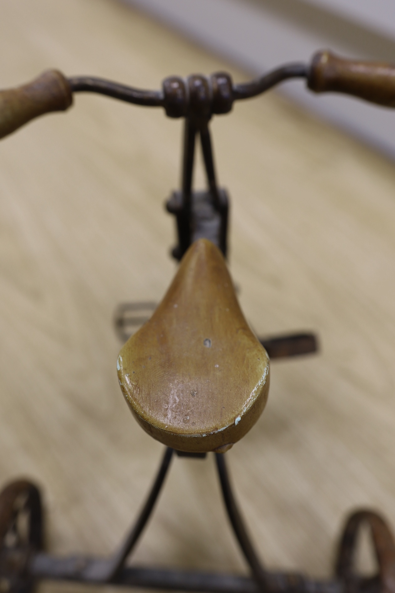 A cast iron toy model of a tricycle, a carved wooden bow, a classical figurative door knocker, a pair of metal cow shoes and two ceramic cistern pulls, bowl 30cm diameter. Condition - fair